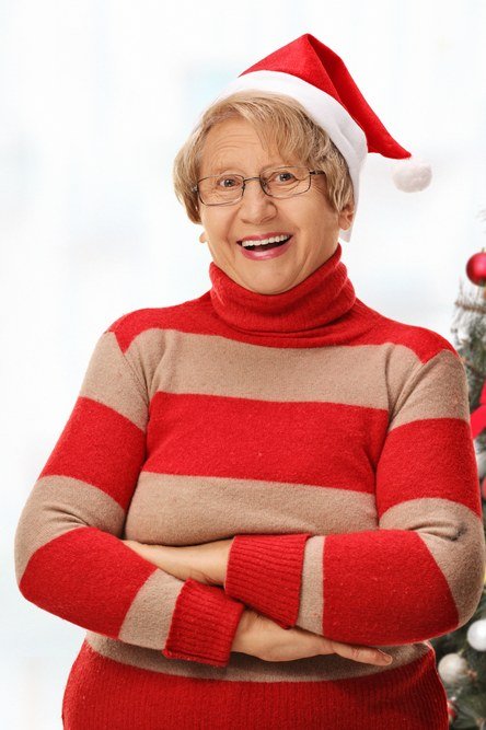 Red and cream striped turtleneck with Santa hat by Christmas tree, fun holiday outfit for women over 70